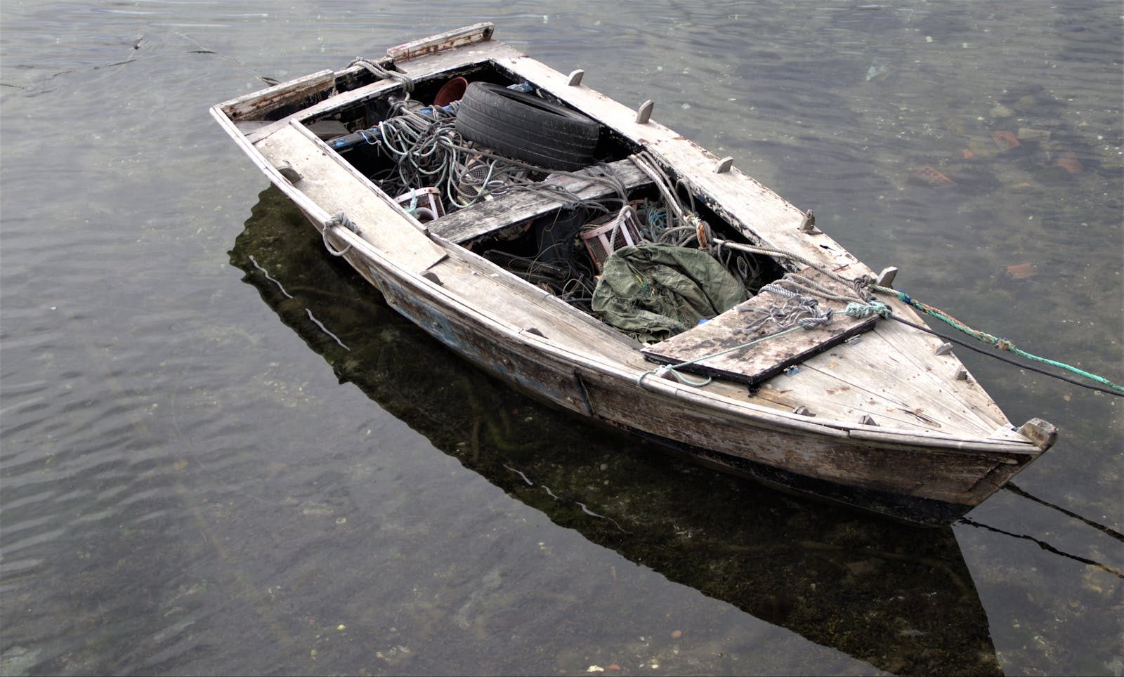 A wooden boat filled with fishing gear floats quietly in Combarro, Spain.